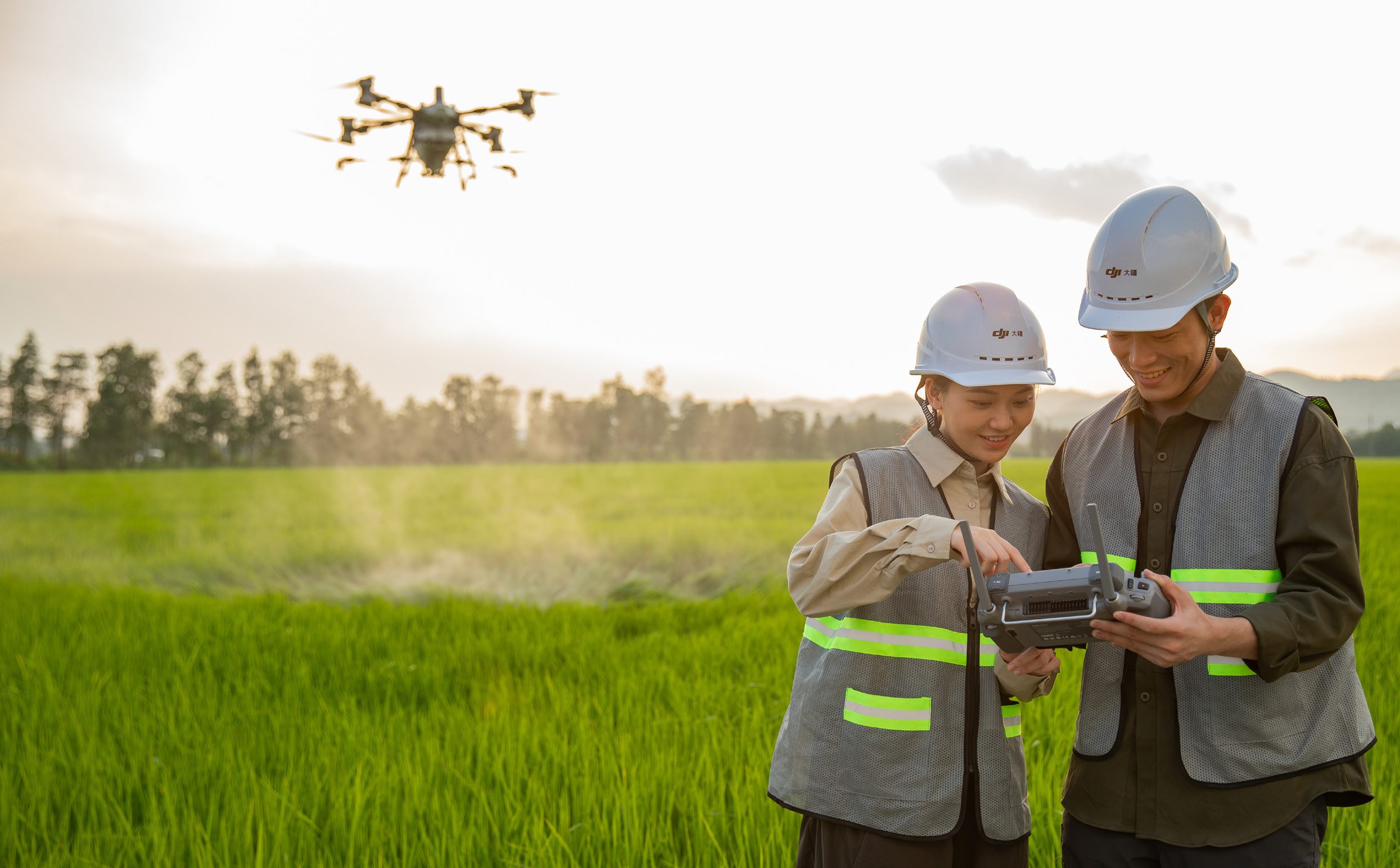 Operadores a observar o comando de um drone agrícola no terreno